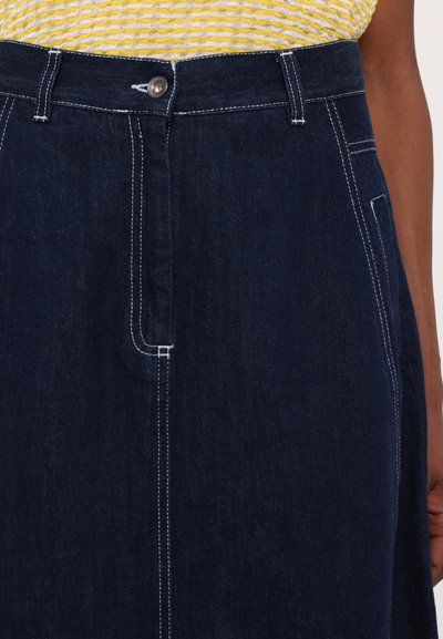 Mørk denim nederdel med høj talje, prydet med hvid syning, frontlukning med knap og sidelommer. Glat tekstur, A-formet pasform.