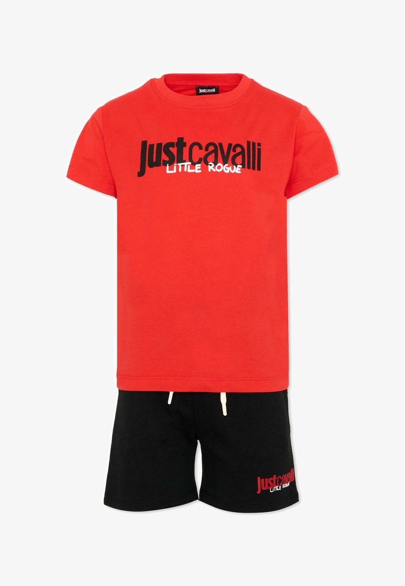 T-shirt rouge à manches courtes avec le texte "Just Cavalli Little Rogue" en noir et blanc, associé à un short noir avec un texte assorti en rouge et blanc.