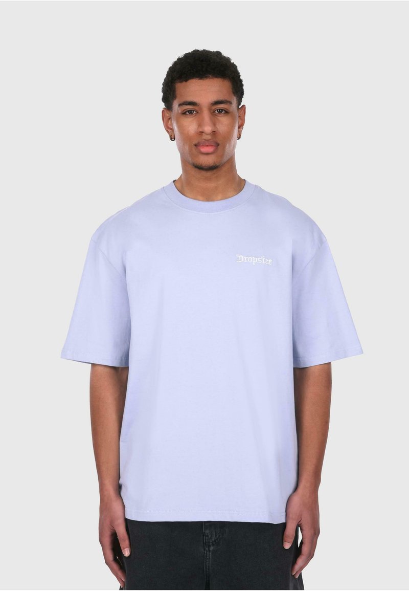 Lys lilla bomull oversized t-skjorte med rund hals og korte ermer, med en liten hvit trykt logo på venstre bryst.