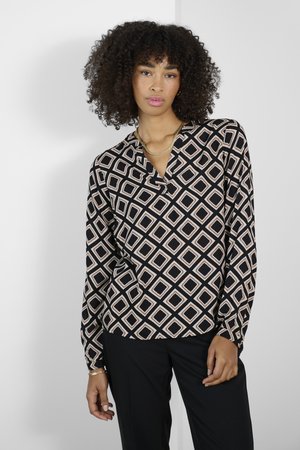 Blouse à manches longues noire avec un motif géométrique en losanges crème et pêche, dotée d'un décolleté en V et d'une texture soyeuse.