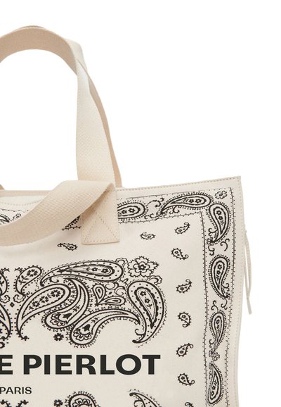 Bolsa de lona en beige con estampado de paisley negro y asas gruesas. Gran impresión "LE PIERLOT PARIS" en la parte inferior. Presenta una forma estructurada.