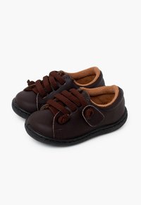 Braune Lederschuhe mit dunklen Schnürsenkeln, runder Spitze, weichem, hellbraunem Futter und einer flexiblen schwarzen Gummisohle. Klettverschluss für einen sicheren Halt.