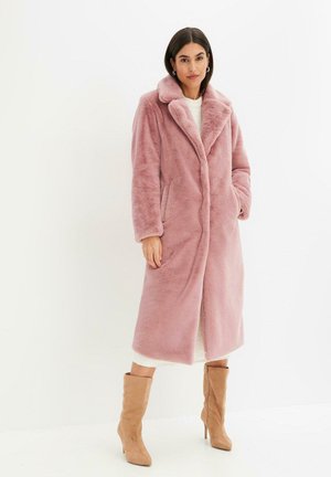 Manteau long en fausse fourrure rose avec un col cranté, des boutons à l'avant et des poches latérales. Longueur sous le genou avec une texture douce. Porté ouvert.