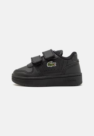 Baskets noires pour enfants avec deux bandes Velcro, logo crocodile Lacoste vert sur le côté et marquage en relief Lacoste sur la semelle.