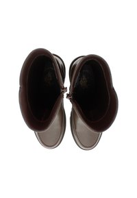 Botas de cuero marrón hasta el tobillo con punta redondeada, textura suave, cremalleras laterales y acentos marrones en contraste en la suela y el cuello.