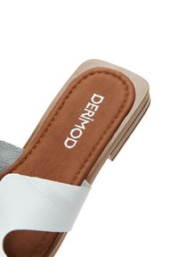 Sandales à bout ouvert grises claires et blanches avec une semelle intérieure texturée marron et des détails de couture subtils, dotées d'un petit talon carré.