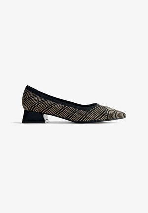 Zapato plano de punta afilada con tacón bajo, que cuenta con una parte superior de tela a rayas diagonales en negro y beige, y un tacón negro.