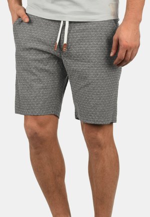 Grijze shorts van textuurstof, met een elastische tailleband met witte trekkoorden en bruine accenten. Er zijn zakken aanwezig.