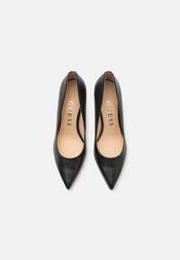 Scarpe nere in pelle con tacco alto e punta affilata, dalla texture liscia e con un logo del marchio, presentano uno stile slip-on per un facile indossamento.