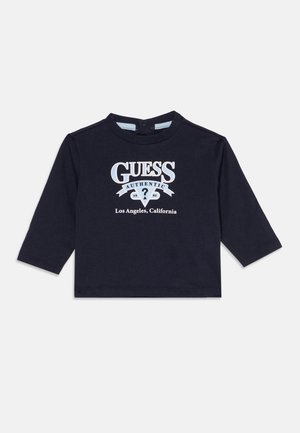 Czarna koszulka z długim rękawem dla małego dziecka z nadrukiem "GUESS Authentic 1981 Los Angeles, California" na przodzie w białym i jasnoniebieskim kolorze.