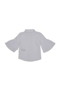 Chemise blanche à manches longues avec manches évasées et plissées et col pointu, vue de dos sur un fond uni.