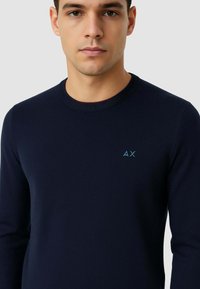 Maglione a maniche lunghe a maglia di colore blu navy con scollatura a girocollo e piccolo logo azzurro sul petto. Texture morbida, design aderente.