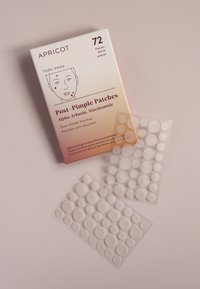 Emballage blanc avec un dégradé de pêche à rose, étiqueté "Patches Post-Poutre". Comprend des patches transparents, ronds de différentes tailles.