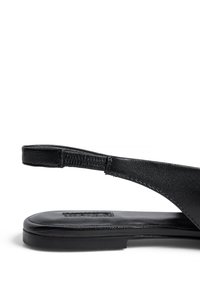 Must musta slingback sandaal, millel on lame talla, minimalistlik disain, sile tekstuur ja õhuke pahkluusi rihm.