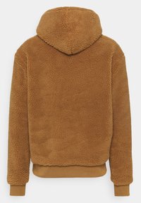 Brown fleece hoodie with a textured surface, adjustable hood, and ribbed cuffs. Features a relaxed fit and elastic bottom hem.