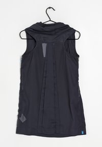 Mörk marinblå ärmlös väst med huva, med en plisserad rygg, blixtlåsfickor på sidan och kontrasterande tyginslag. Texturerat, lätt material.