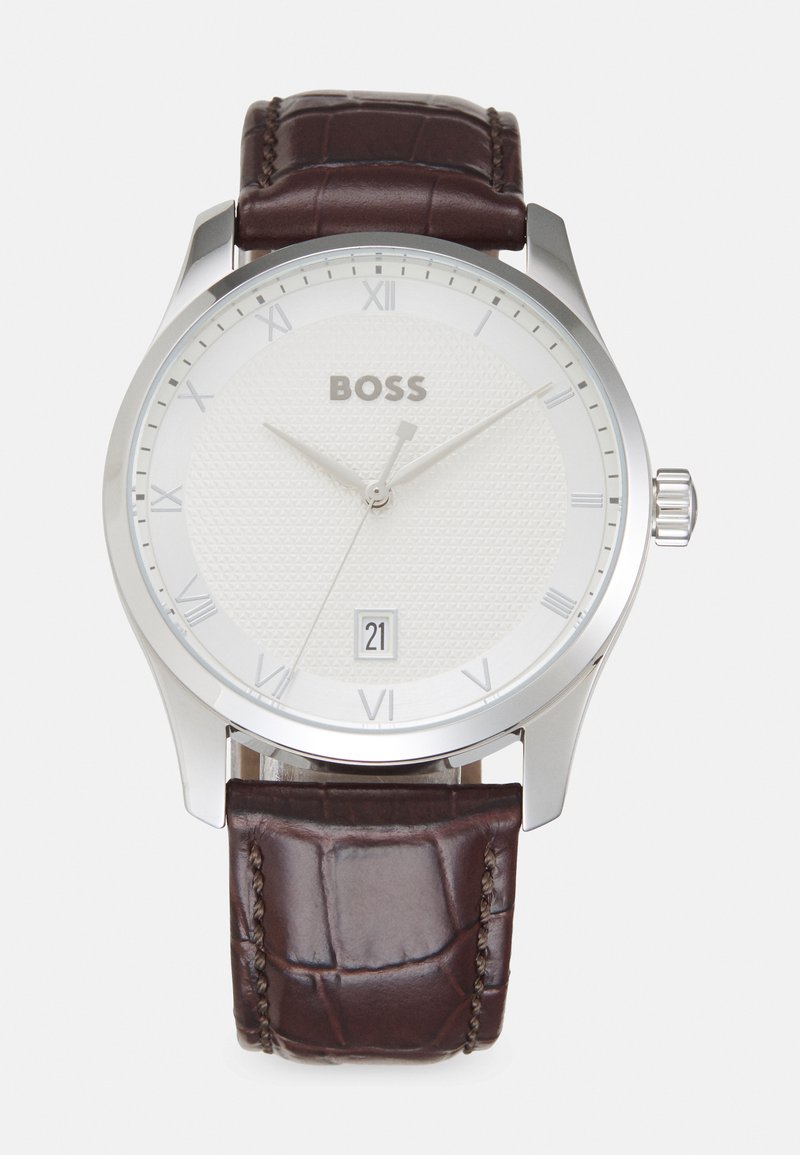 Reloj de bolsillo para hombre en tono plateado con un dial texturizado en blanco, números romanos y un indicador de fecha. Correa de cuero grabado de cocodrilo en color marrón.