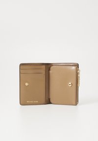 Cartera de cuero marrón con detalles en dorado, que incluye compartimentos para tarjetas, un cierre a presión y una textura suave. Logo grabado en el interior.