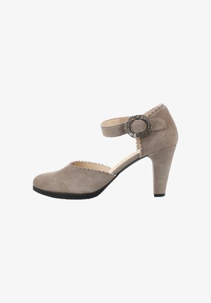Beiger Wildleder-Pumps mit hohem Absatz, gewelltem Rand und einem Knöchelriemen mit verzierter silberner Schnalle, seitlich dargestellt.