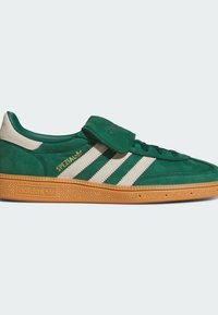Green suede sneakers featuring three white stripes, a gum sole, and a Velcro strap. Branding includes "Spezial" and "adidas" in gold.