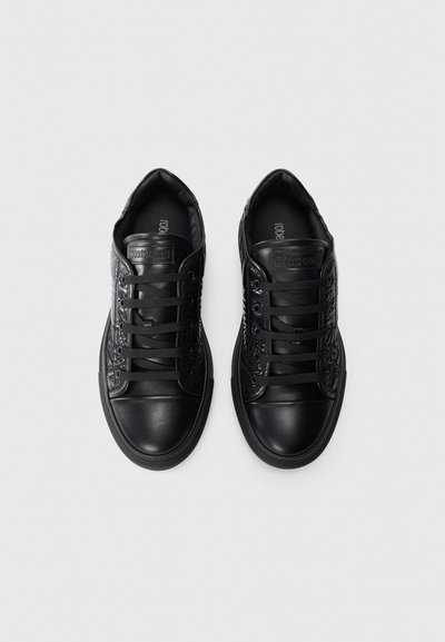 Zapatillas negras con parte superior de cuero suave, acentos texturizados y cordones planos. Presenta una puntera redondeada y suela de goma para mayor agarre.