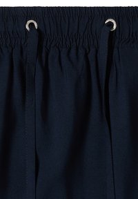 Ceinture élastique bleu marine avec deux cordons noirs passés à travers des œillets métalliques sur un vêtement en tissu.