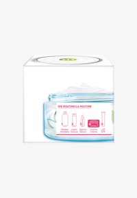 Przezroczysty słoik z jasnoniebieskim akcentem, zawierający białą kremową substancję oraz zielony liść, obok biała pudełko z instrukcją stosowania produktu.