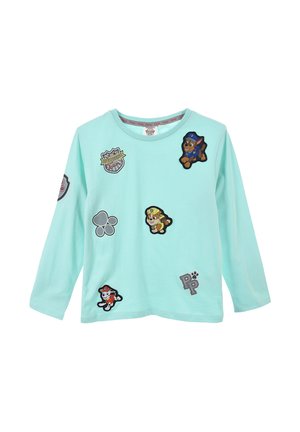 Camiseta de manga larga verde menta clara con varios parches bordados que presentan perros de dibujos animados, logotipos y huellas en colores contrastantes.