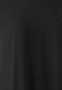 T-shirt nera realizzata in tessuto liscio. Presenta un design semplice con maniche corte e scollatura rotonda, mostrando una texture opaca.