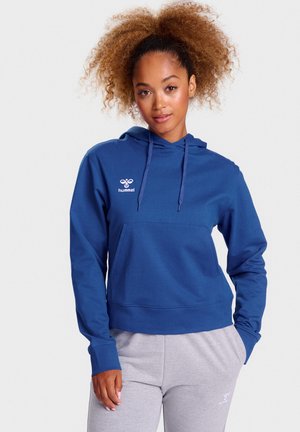 Sweat à capuche bleu marine avec cordon de serrage et poche avant. Présente un logo "hummel" blanc sur la poitrine. Tissu doux et coupe décontractée.