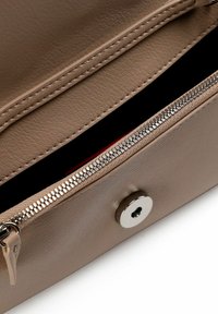 Borsa in pelle beige con chiusura a zip, caratterizzata da una texture liscia, dettagli in metallo argentato e interno nero a contrasto. Arricchita da un bottone a pressione.