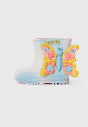 Botte en caoutchouc blanche avec une base dégradée bleue, doublure rose et un grand accent de papillon coloré fixé au talon. Logo sur le côté.