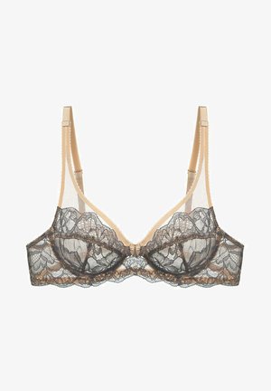 Soutien-gorge en dentelle avec un revêtement en dentelle noire sur une base chair, support à armature, bords festonnés et bretelles ajustables. Détail en forme de nœud au centre avant.
