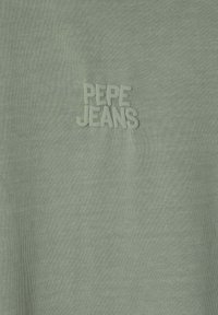 Svetlozelené tričko vyrobené z mäkkého materiálu s vyšitým textom "PEPE JEANS" na hrudi, s hladkou textúrou.
