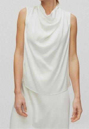 Biała satynowa bluzka bez rękawów z marszczonym dekoltem, noszona przez kobietę, widzianą od ramion do bioder na jednolitym tle.