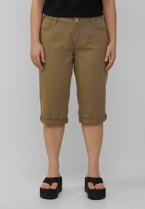 Bruine cargo pantalons tot de knie met een opgerold uiteinde, voorzakken en een knoopsluiting, gecombineerd met zwarte platform sandalen.