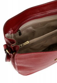 Borsa a tracolla rossa in pelle con una superficie liscia, dotata di due tasche con cerniera e una fodera interna beige con un motivo sottile.