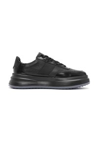 Zapatilla negra con parte superior de cuero texturizado, acentos lisos, cierre de cordones y una suela gruesa tipo plataforma con un borde translucido.