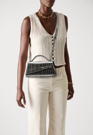 Black leather handbag with a structured design, featuring a top handle, chain shoulder strap, and textured vertical stripes.
