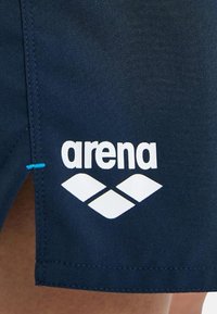 Bañadores de natación azul marino con el logotipo blanco "arena" y cuatro formas de diamante; incluye costura de acento azul en el lateral; material sintético suave.