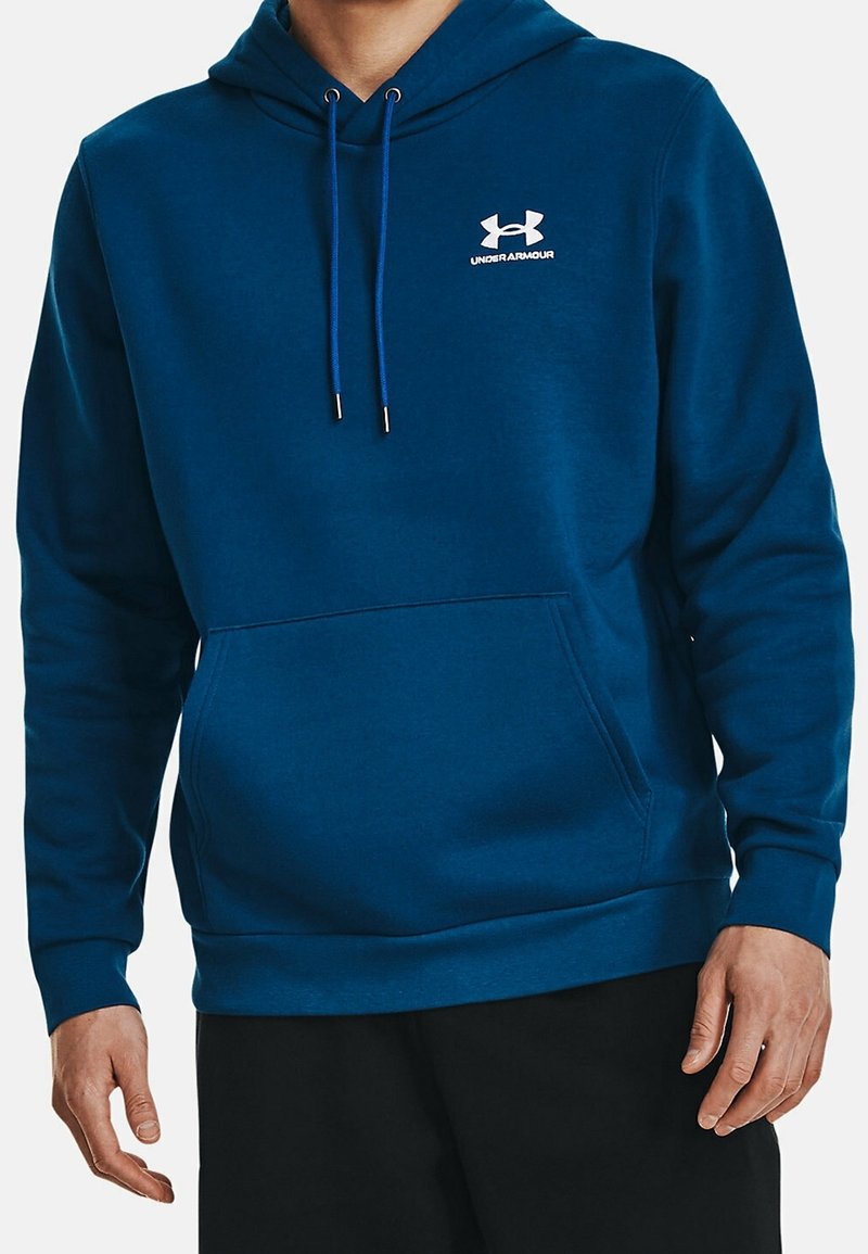 Sweat à capuche bleu en tissu doux, avec une poche avant, des cordons ajustables et un petit logo Under Armour blanc sur la poitrine.