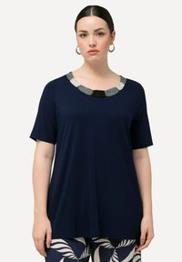 Top corto navy a maniche corte con scollatura rotonda decorato con un design a perline geometriche testurizzate in tonalità di argento, nero e beige.