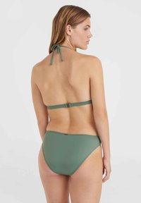 Zaļš bikini komplekts ar haltera topu un regulējamām saitēm, kā arī minimālu seguma apakšu. Gluda auduma struktūra ar smalku spīdumu.