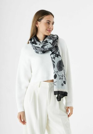 Écharpe légère à motif floral en gris et noir, fabriquée en tissu doux avec un léger éclat et une finition noire sur les bords.