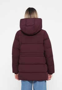 Burgundy puffer jacket with a hood, featuring vertical stitch lines, a slightly textured finish, and a mid-length design.