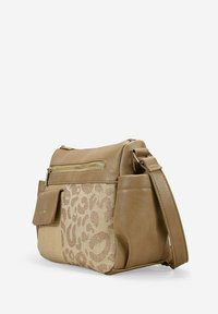 Bolso de mano beige con cuero sintético texturizado y tejido entrelazado que presenta un sutil estampado de leopardo, bolsillos con cremallera y una correa ajustable.