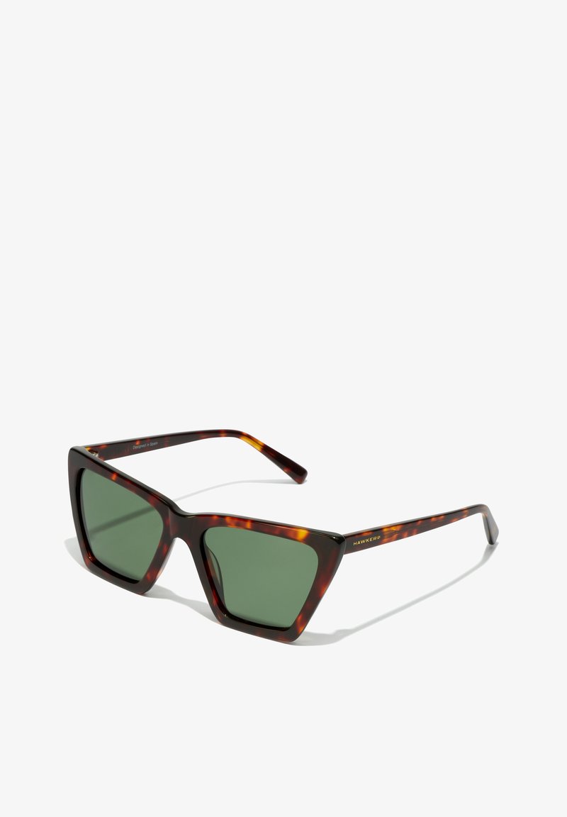 Ochelari de soare cu ochet tortoise, lentile verzi, formă geometrică a ramei și branding auriu "HAWKER" pe bratul ochelarilor. Textură netedă, brațe late.
