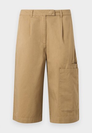 Μπεζ cargo σορτς μέχρι το γόνατο με πλαϊνό τσεπάκι, θηλιές για ζώνη και πιέτες μπροστά, κατασκευασμένα από ανθεκτικό ύφασμα.