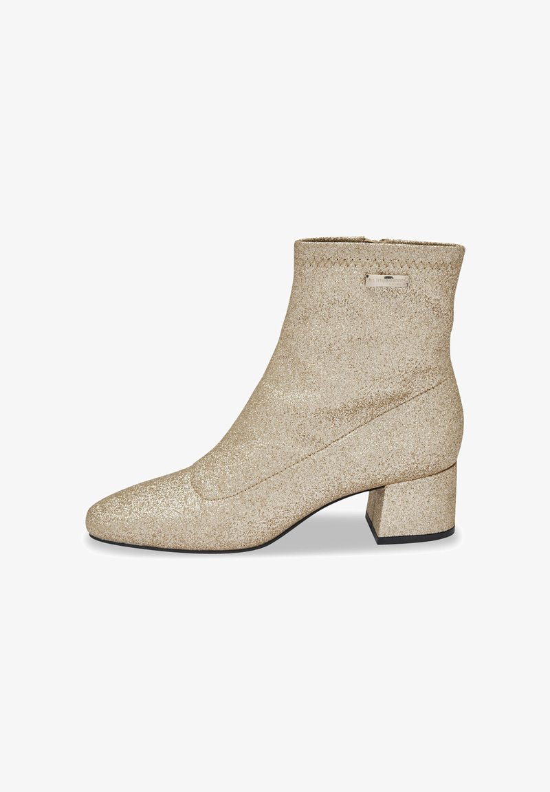 Bottine dorée scintillante avec un bout pointu et un talon carré. Matériau doux et texturé avec un détail de couture et un accent de logo en métal.