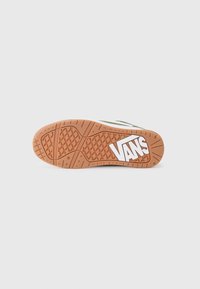 Suela de zapatilla con una base de goma marrón texturizada, con un logo blanco y un diseño de agarre patrón para tracción.